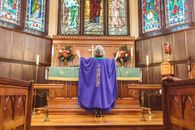 Person in Cassock Standing on Altar