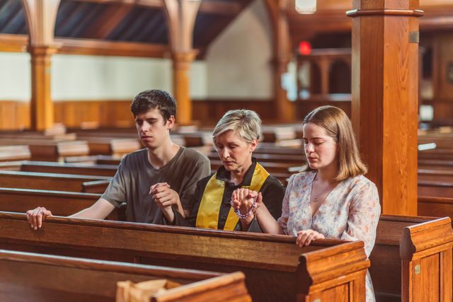 Church members holding hands and praying together