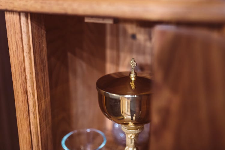 Golden Chalice On Wooden Cabinet