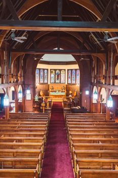 High angle view of a beautifully designed empty church interior featuring wooden pews and stained glass.