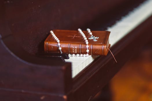 A Bible and rosary resting on a piano, symbolizing faith and music harmony.