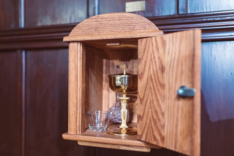 A Chalice And Glass Inside A Wooden Tabernacle