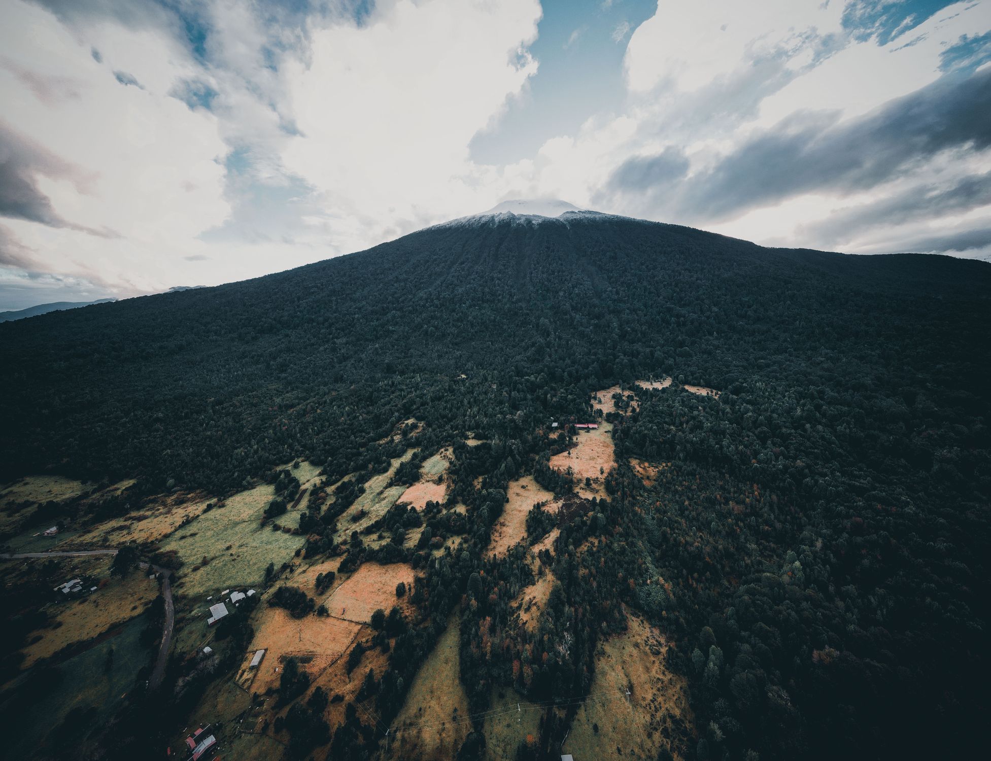 Drone view of Hornopirén Volcano, showcasing lush forests and scenic landscapes in Los Lagos, Chile.