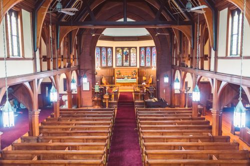 Free A beautiful church interior featuring wooden pews and vibrant stained glass windows. Stock Photo