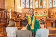 Eldelry Woman Standing in front of Parishioners