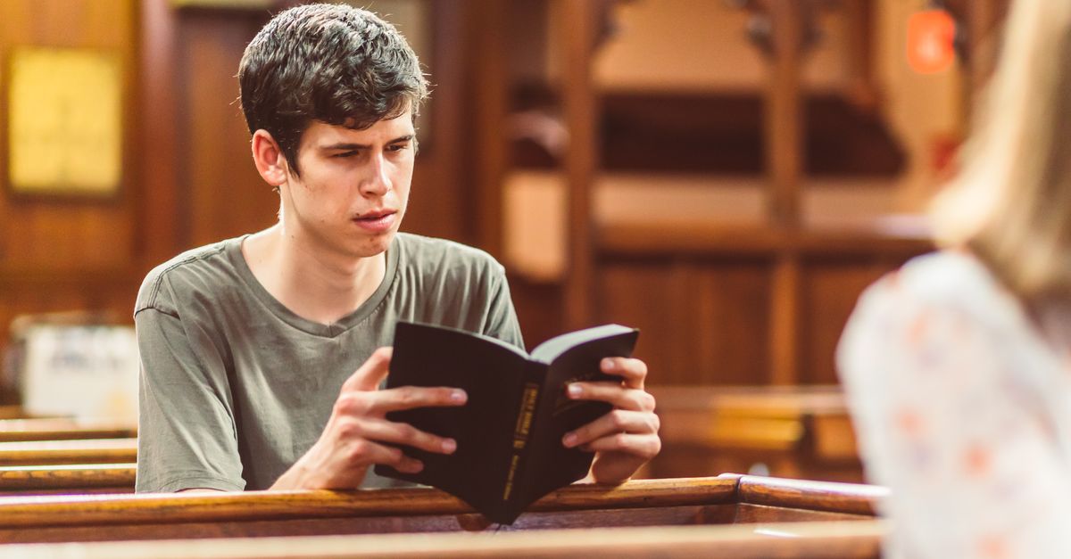 young person praying alone in a sunlit church pew