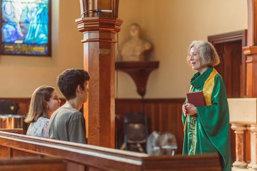 Woman Pastor Standing In Front of Couple 