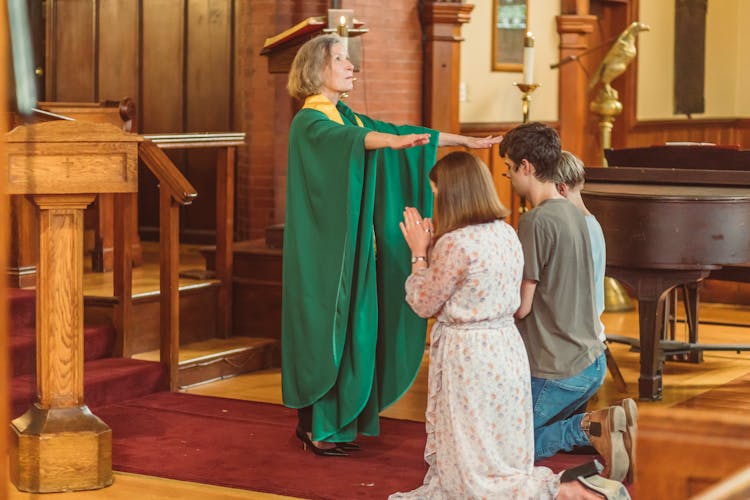 Woman Gives Blessing To People Kneeling Down