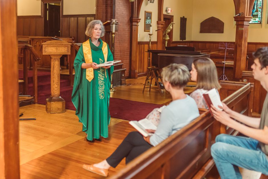 Pastor at pulpit with protesters