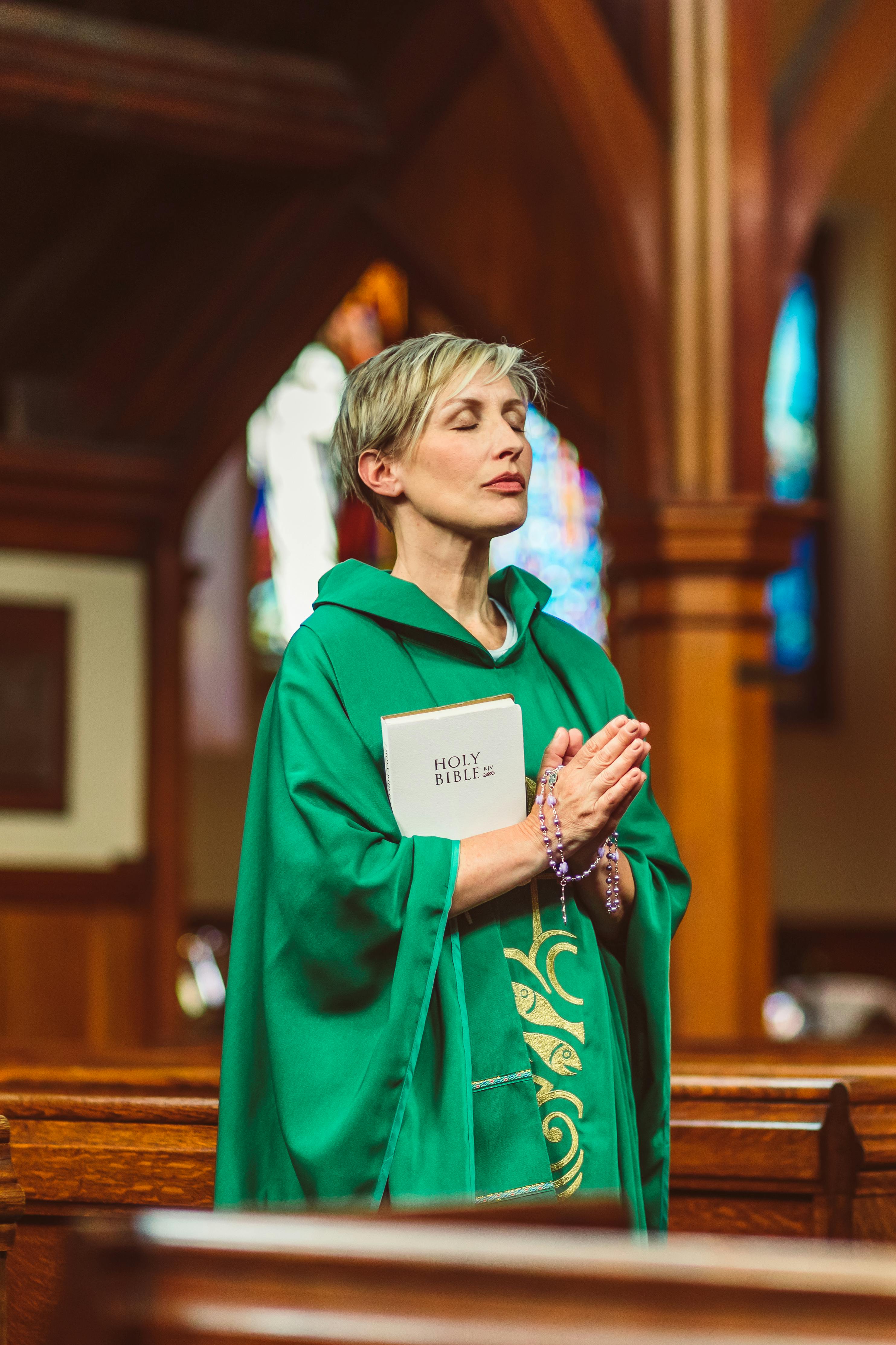 female priest praying solemnly