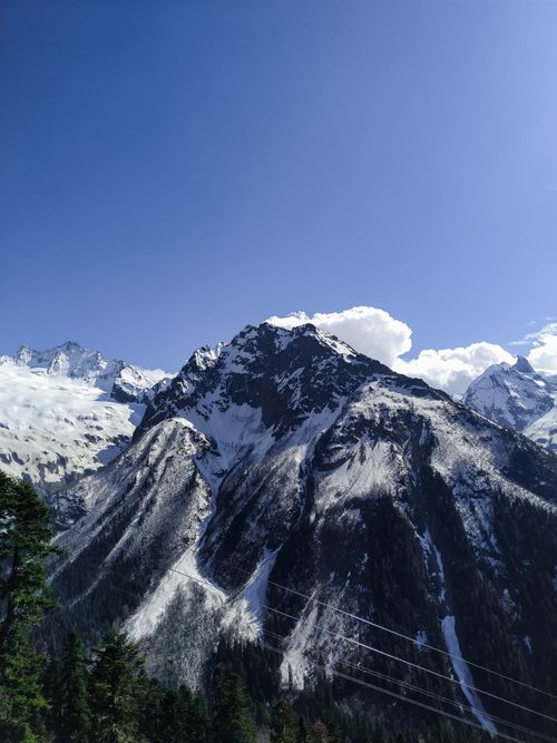 Free Breathtaking view of the snow-capped mountains in Dombay, Russia with clear blue skies. Stock Photo