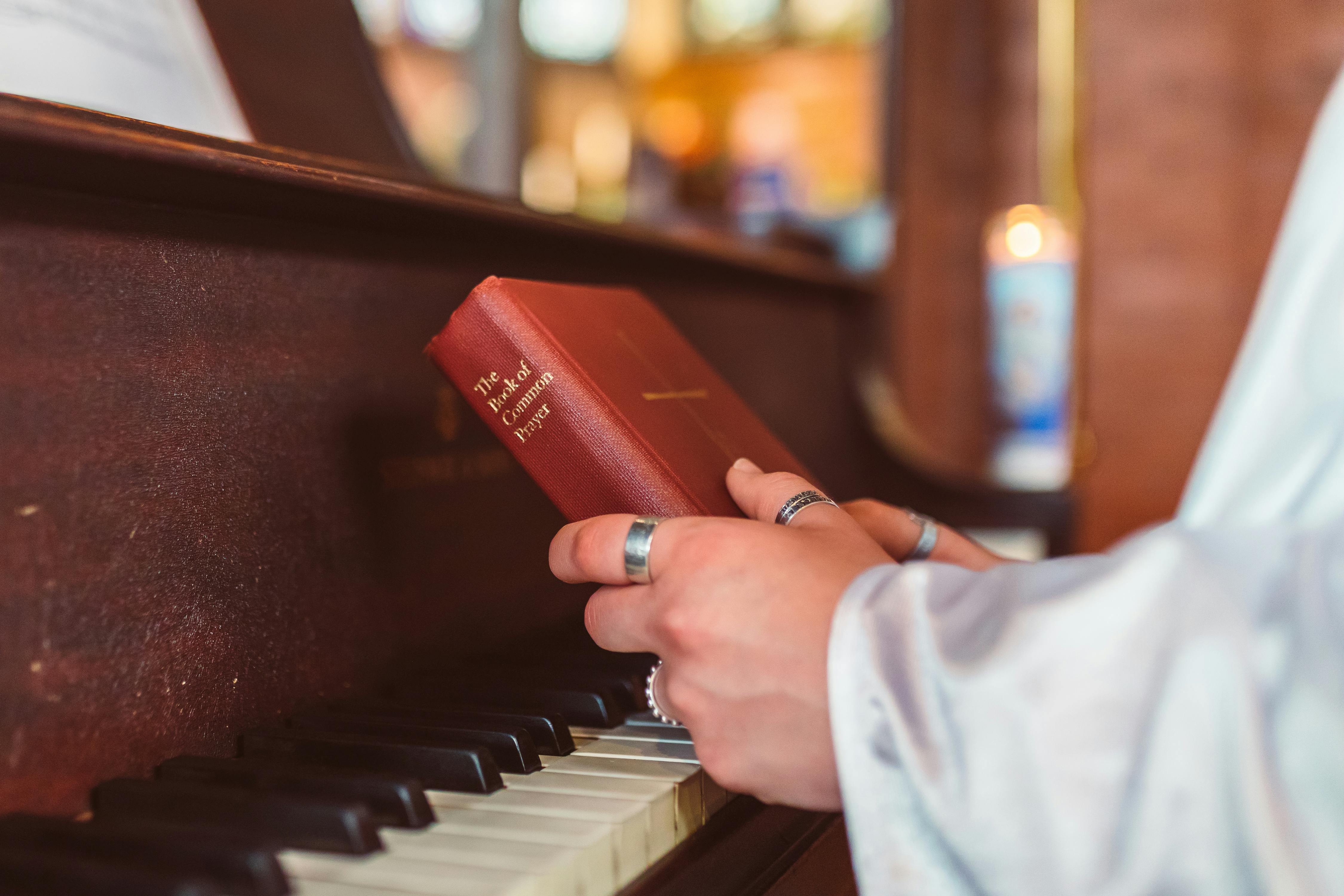 holding a bible near the piano