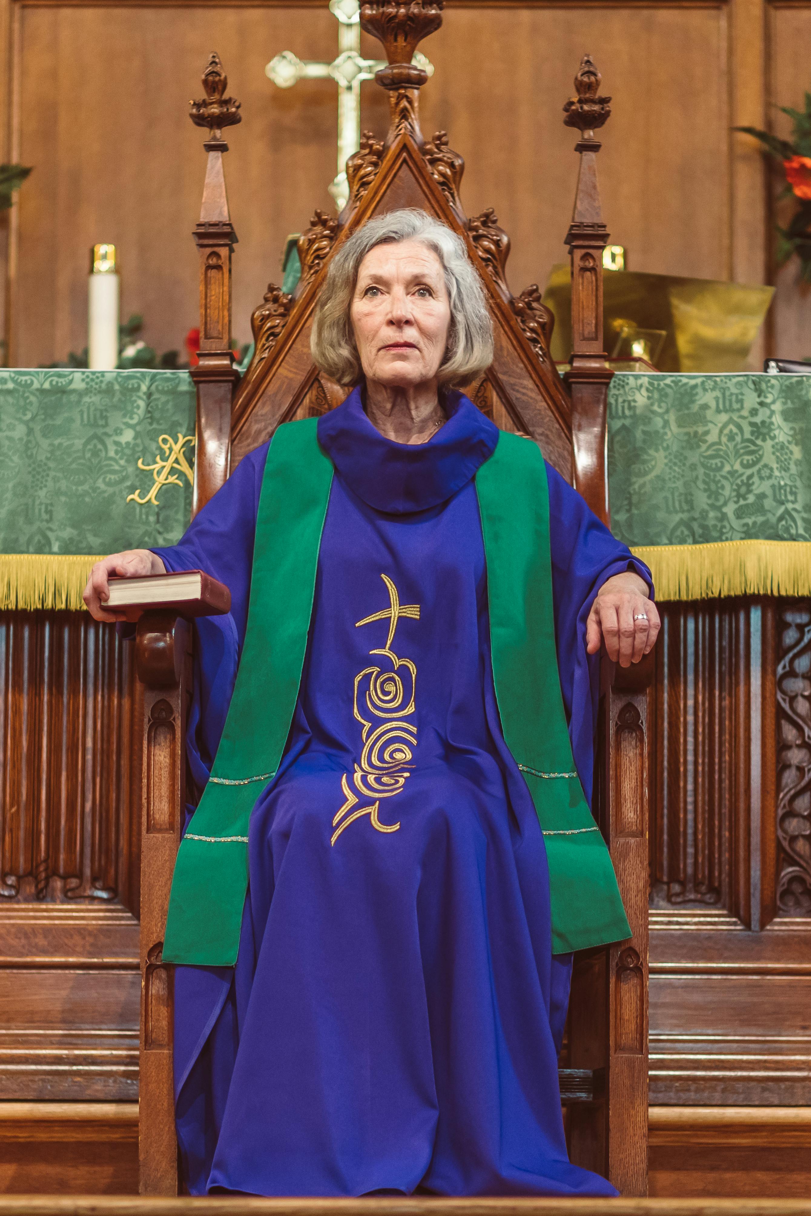 Female Priest Sitting on a Wooden Chair Inside a Church · Free Stock Photo