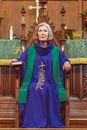 Female Priest Sitting on a Wooden Chair Inside a Church