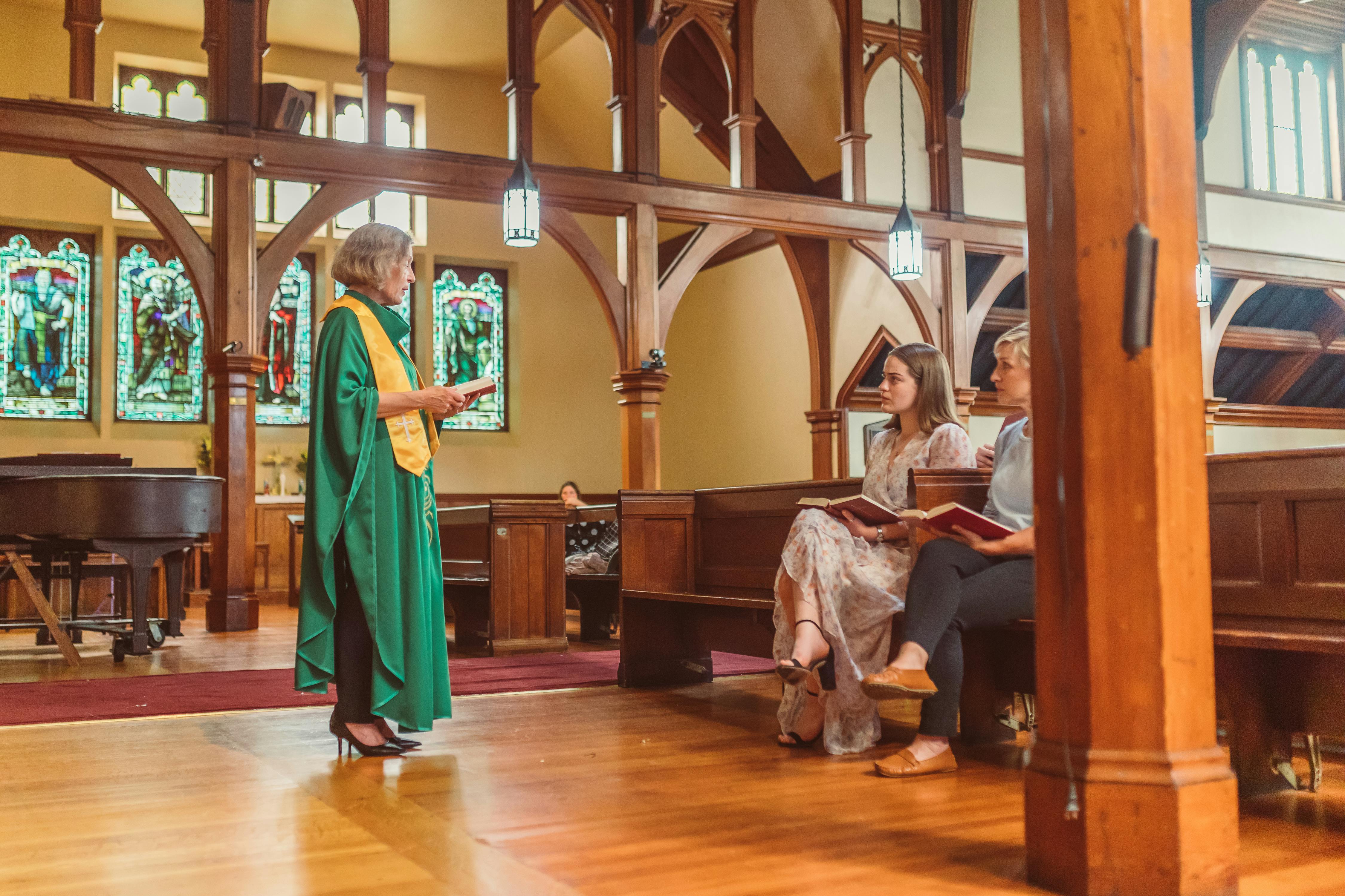 female priest giving sermon to the parishioners