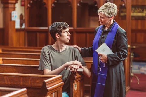 A Female Priest Talking to a Man