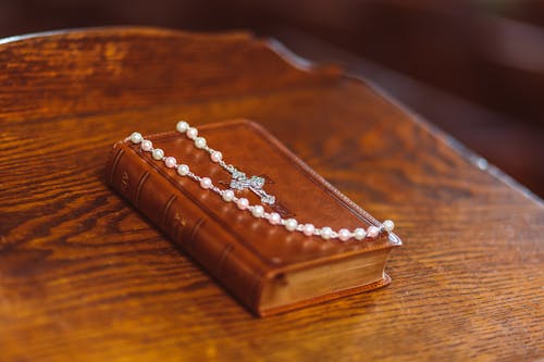 Free Bible and Rosary on Wooden Surface  Stock Photo