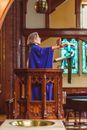 A Woman Priest in a Wooden Pulpit while Preaching