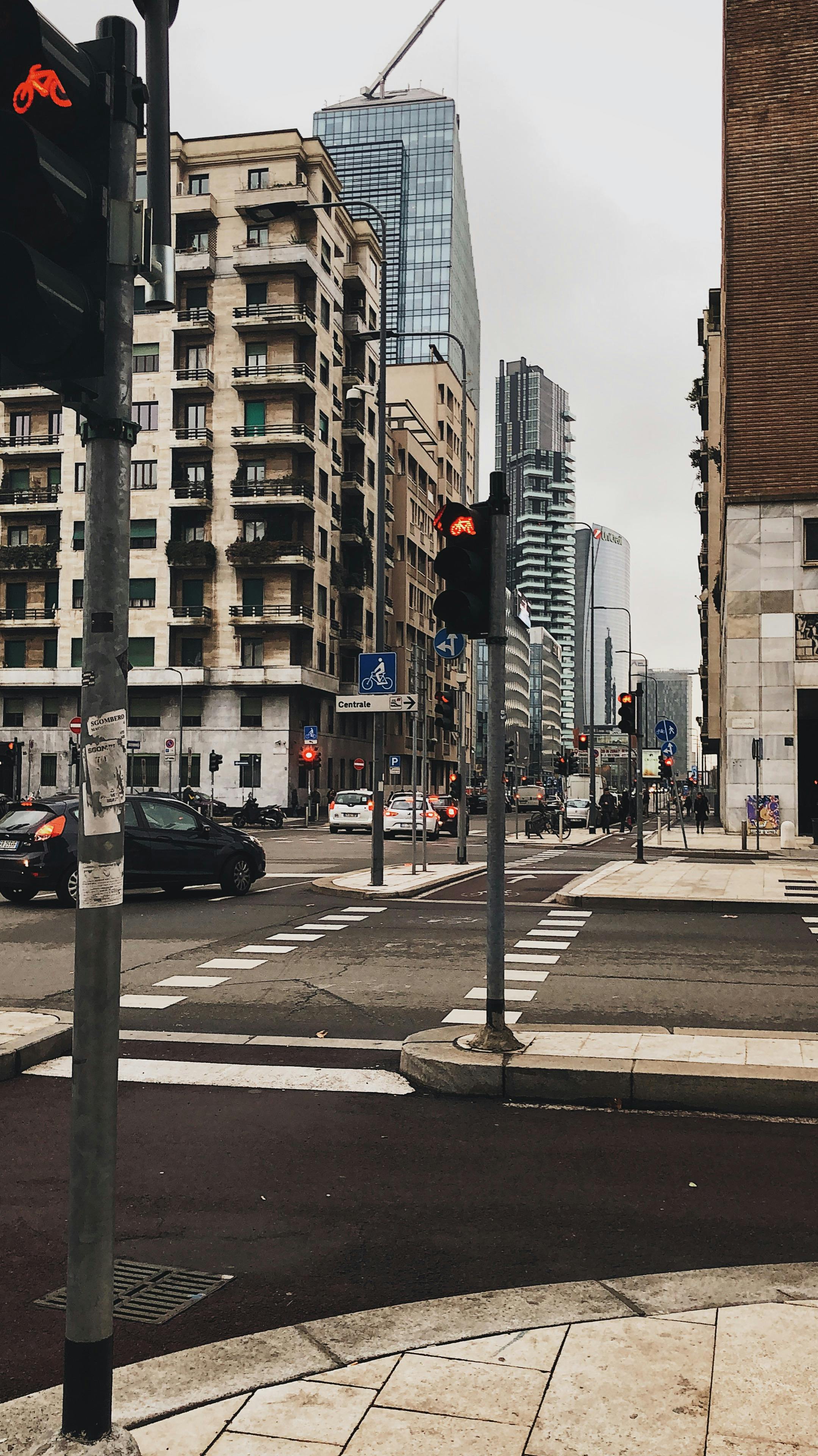 A city intersection with traffic lights, buildings, and skyscrapers. Captured on an overcast day.