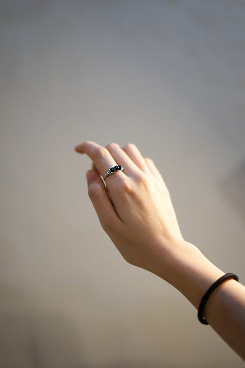 Free Photo of a Person's Hand with a Black and Silver Ring Stock Photo