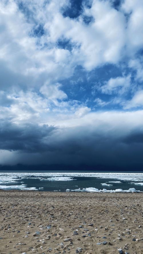Free Beautiful Siberian beach view with icebergs under a dramatic cloudy sky. Stock Photo