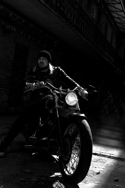 Grayscale Photo of Man Riding Motorcycle