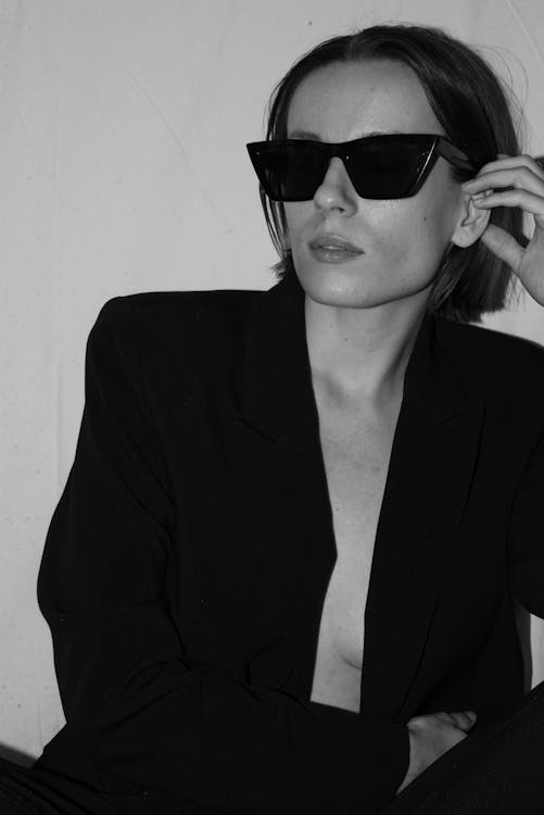 A Woman Wearing Sunglasses and a Black Blazer 
