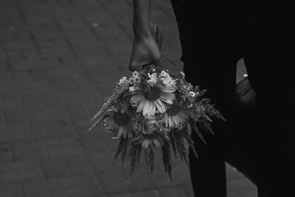 Grayscale Photo of Person Holding Flower Bouquet · Free Stock Photo