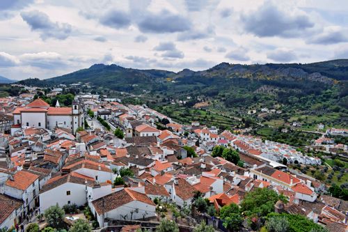 Free Aerial view of Marvão's charming white houses and red roofs against a mountainous backdrop in Portugal. Stock Photo