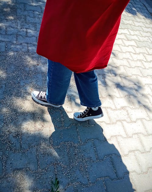 A Person in Denim Pants and Black and White Sneakers