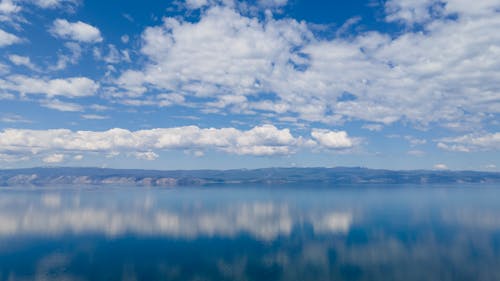 Blue Sky and White Clouds over the Body of Water 