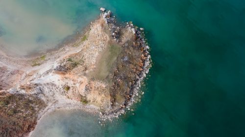 Free Captivating aerial shot of a rocky peninsula surrounded by the turquoise sea in Russia. Stock Photo