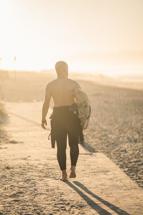 Photo of Man Carrying A Surfboard