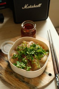 Delicious dish garnished with fresh cilantro, ready to eat with chopsticks.