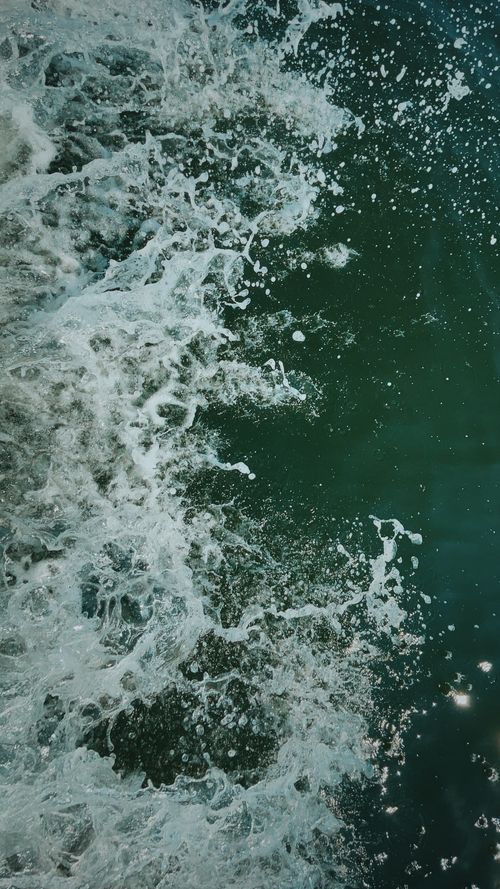 Free Capture of ocean waves crashing, showcasing vibrant green water and dynamic sea foam splash. Stock Photo
