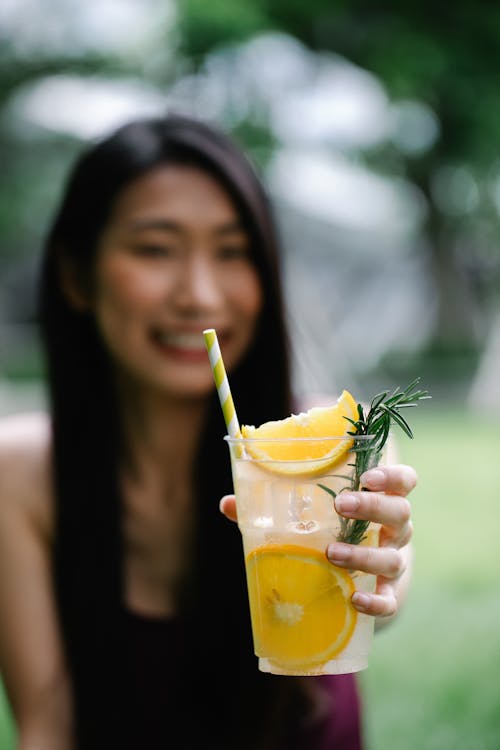 Selective Focus Photo of a Woman Holding a Lemonade Drink