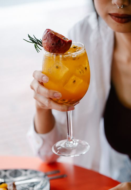 Free Vibrant citrus cocktail with pomegranate and rosemary garnish, perfect for a refreshing drink. Stock Photo