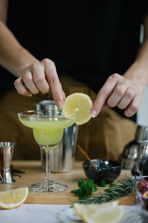 Free Person Hanging Slice of Lemon on Cocktail Glass Stock Photo