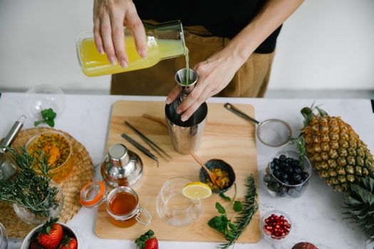 A Person Pouring Juice on a Jigger