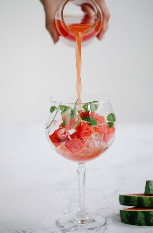 A Person Pouring Red Liquid in the Glass