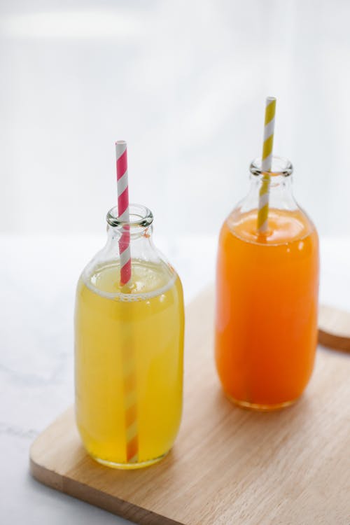 Free Бесплатное стоковое фото с апельсиновый сок, белый фон, бутылки Stock Photo