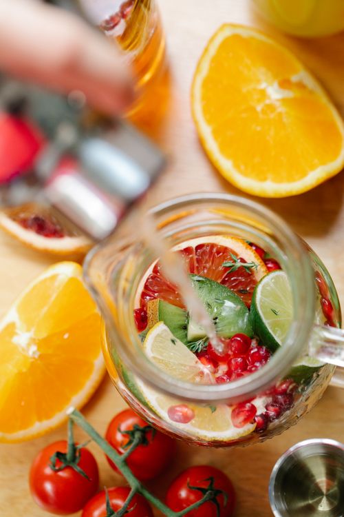 Free A vibrant pitcher of citrus and fruit infused water being poured, showcasing fresh ingredients. Stock Photo
