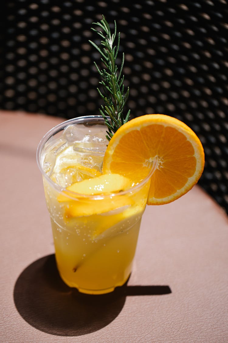 Cocktail With Sliced Orange And Rosemary Garnish