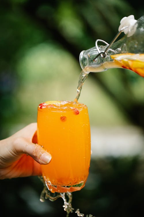 Pitcher filled with freshly-squeezed orange juice being poured into a clear  glass Stock Photo by wirestock