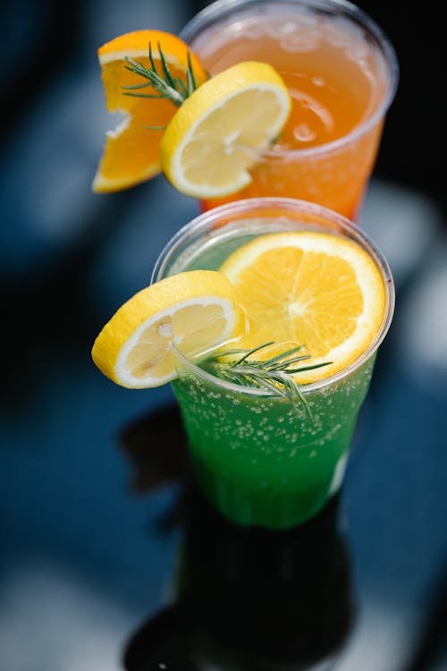 Free Clear Drinking Glasses With Colored Liquid and Sliced Lemon Stock Photo