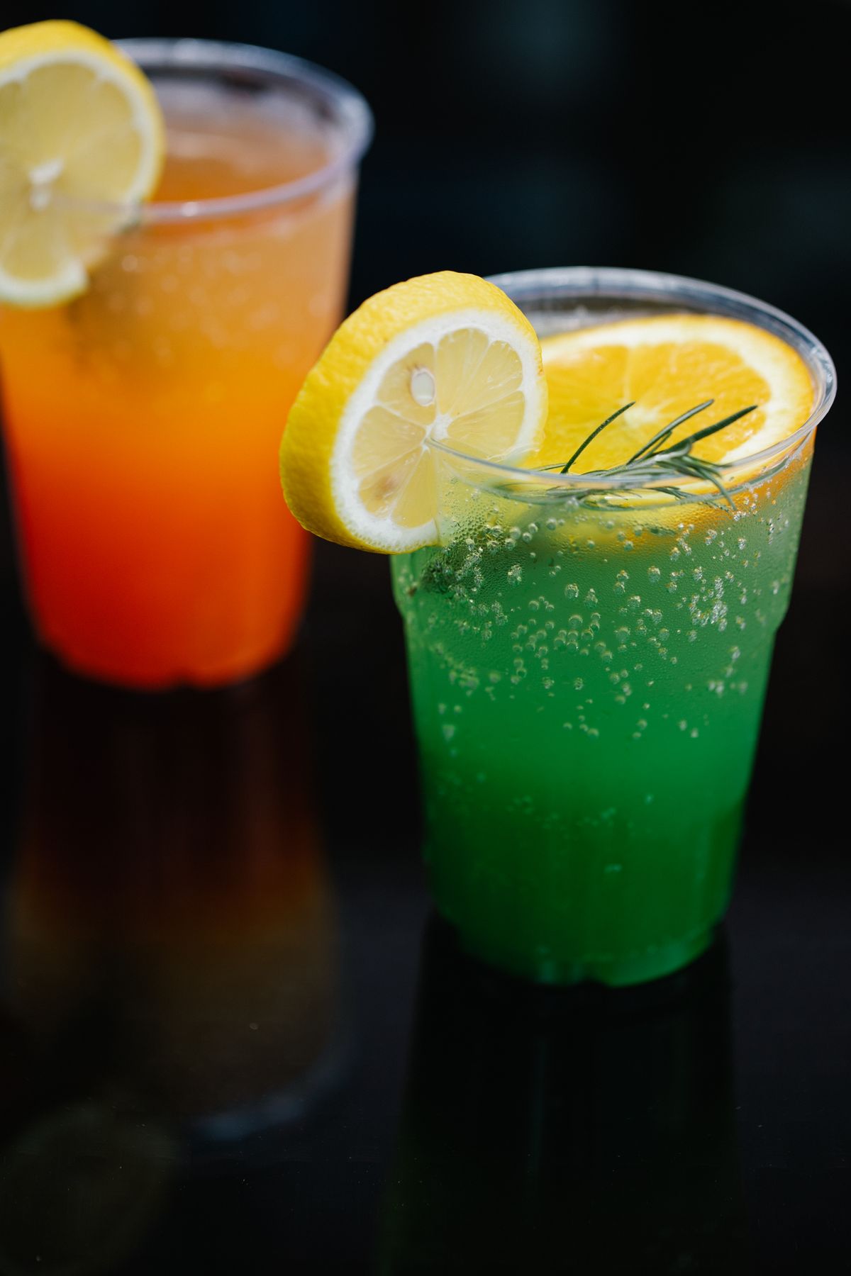 Two colorful non-alcoholic mocktails with lemon slices in clear glasses, party games for adults without alcohol