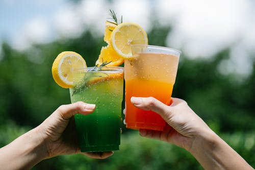 People Holding Drinks in Close Up Photography