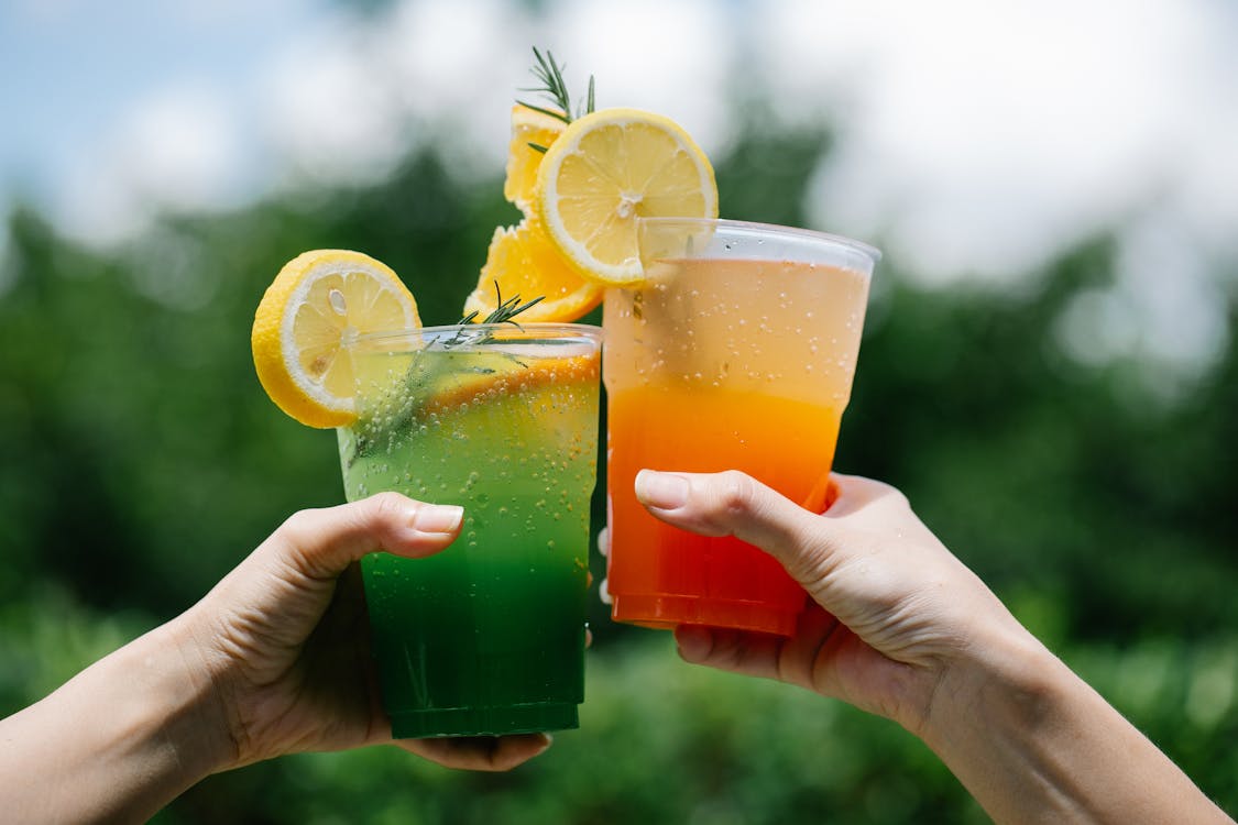 People Holding Drinks in Close Up Photography