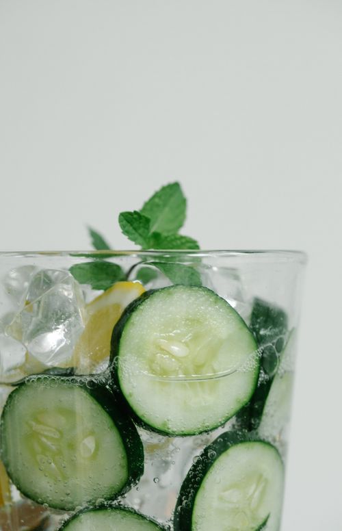 Free Glass of refreshing cucumber and mint detox water with ice cubes and lemon. Stock Photo