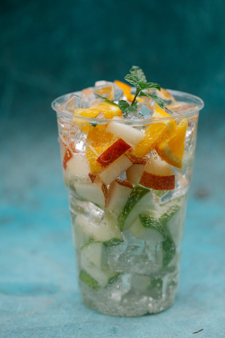 Cup With Water, Ice Cubes And Fruit 